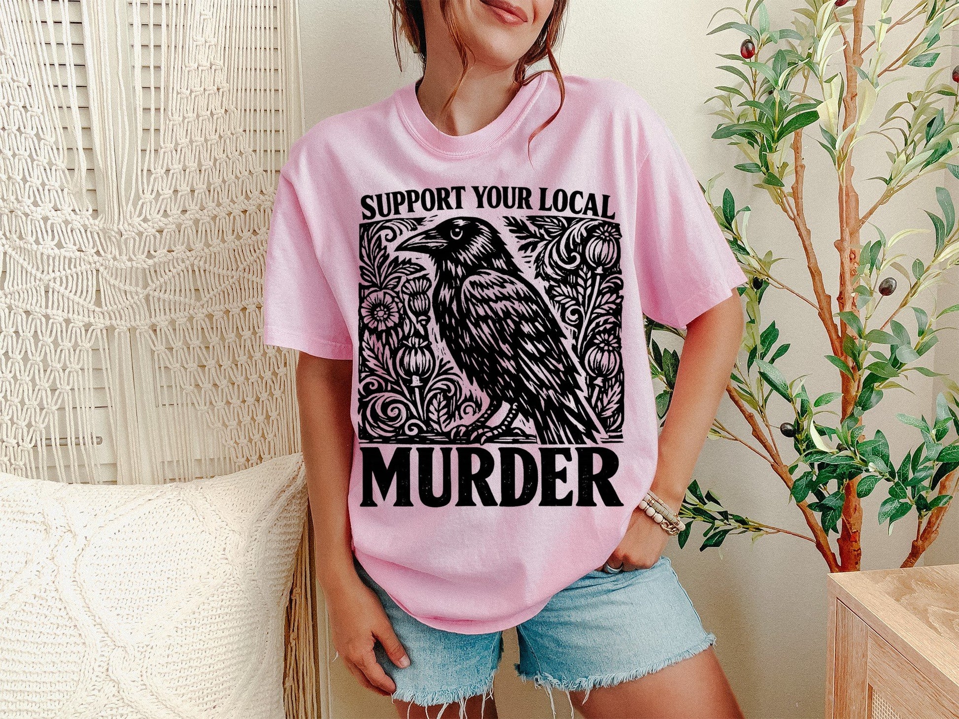 A Blossom Unisex Garment-Dyed T-shirt mockup (front view) showing the support your local murder crow shirt - funny bird lover gift tee print on the front. The artwork highlights shirt, -, funny, bird, lover, gift, tee, unisex, garment-dyed, t-shirt, describing the graphic and theme on the garment.