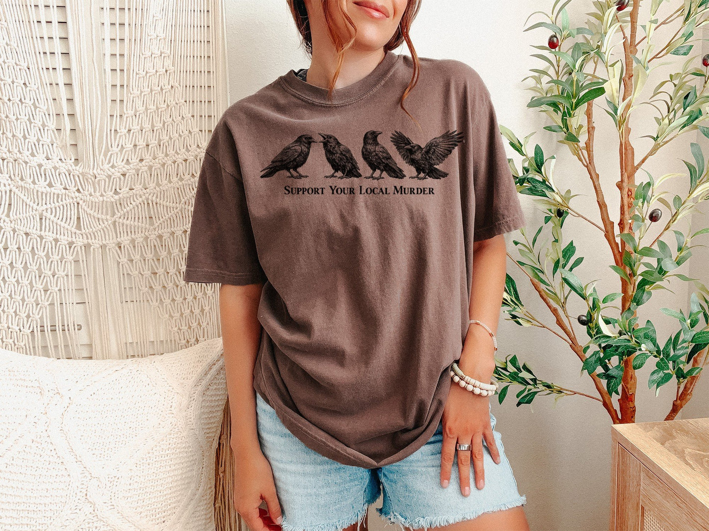 A Espresso Unisex Garment-Dyed T-shirt mockup (front view) showing the support your local murder crow shirt - funny bird lover gift - dark academia raven tee print on the front. The artwork highlights crow shirt, murder of crows, support local murder, funny bird shirt, goblincore, dark academia, raven shirt, bird watcher gift, goth aesthetic, crow lover gift, describing the graphic and theme on the garment.