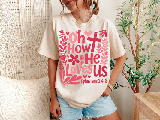 A Ivory Unisex Garment-Dyed T-shirt mockup (front view) showing the oh how he loves us christian shirt jesus loves us graphic tee print on the front. The artwork highlights worship lyrics tee, faith based gift, jesus loves us, aesthetic christian, comfort colors tee, bible verse shirt, religious clothing, boho christian, minimalist jesus, christian girl gift, describing the graphic and theme on the garment.