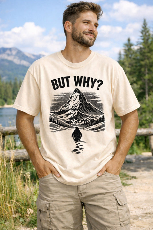 A Ivory Unisex Garment-Dyed T-shirt mockup (front view) showing the nihilist penguin heading to mountains t-shirt - existential humor print on the front. The artwork highlights nihilist penguin, existential humor, werner herzog, funny animal tee, minimalist graphic, meme clothing, unhinged shirt, burnout gift, indie film merch, penguin lover gift, describing the graphic and theme on the garment.