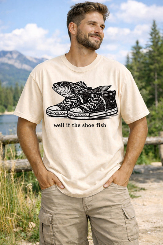 A Ivory Unisex Garment-Dyed T-shirt mockup (front view) showing the well if the shoe fish - absurdist humor graphic t-shirt print on the front. The artwork highlights ironic meme shirt, weirdcore clothing, surreal humor tee, tiktok viral shirt, unhinged graphic tee, fish in shoes, y2k aesthetic, shirts that go hard, cursed image shirt, absurdist fashion, describing the graphic and theme on the garment.