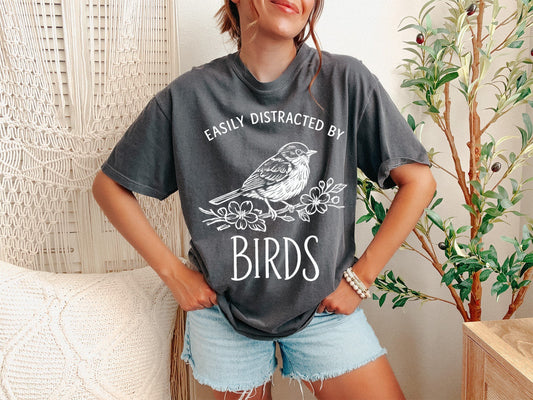 A Pepper Unisex Garment-Dyed T-shirt mockup (front view) showing the retro bird watching t-shirt - vintage bird nerd apparel print on the front. The artwork highlights pepper, retro, bird, watching, t-shirt, -, vintage, nerd, apparel, unisex, describing the graphic and theme on the garment.