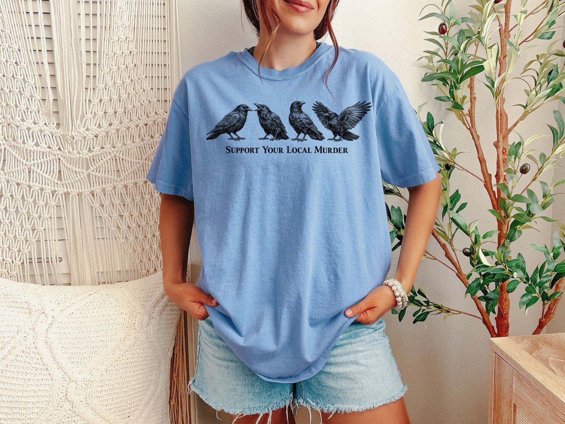 A Washed Denim Unisex Garment-Dyed T-shirt mockup (front view) showing the support your local murder crow shirt - funny bird lover gift - dark academia raven tee print on the front. The artwork highlights bird, lover, gift, dark, academia, raven, tee, unisex, garment-dyed, t-shirt, describing the graphic and theme on the garment.