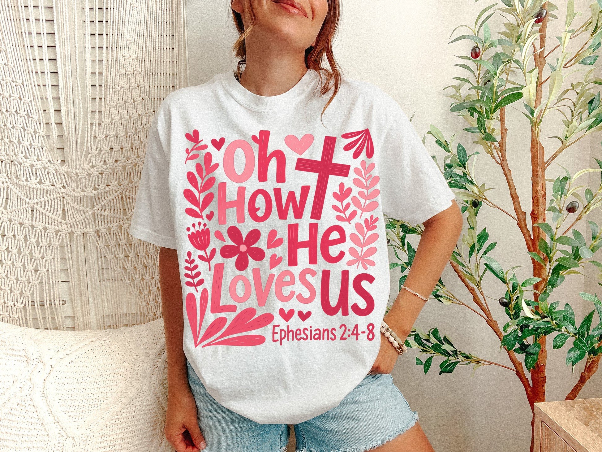 A White Unisex Garment-Dyed T-shirt mockup (front view) showing the oh how he loves us christian shirt jesus loves us graphic tee print on the front. The artwork highlights faith based gift, jesus loves us, aesthetic christian, comfort colors tee, bible verse shirt, religious clothing, boho christian, minimalist jesus, christian girl gift, sunday church shirt, describing the graphic and theme on the garment.